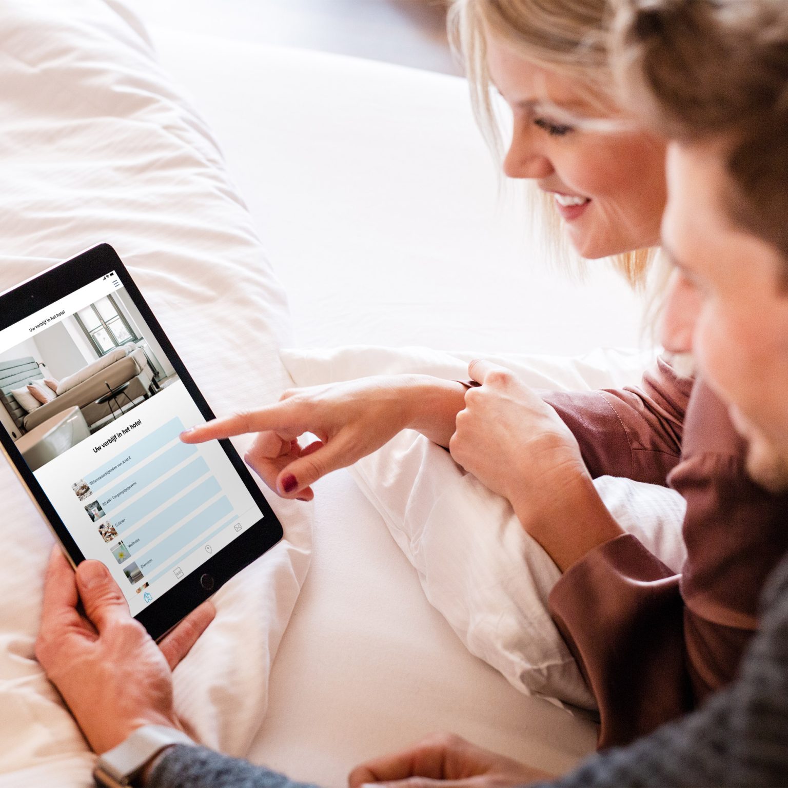 Een stel gebruikt de digitale hotelinformatiemap van Hotelcore op een tablet